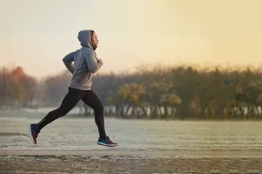 一个年轻的运动员在寒冷的秋天早晨在公园里跑步