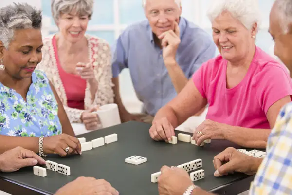 玩多米诺骨牌的一群老年人。