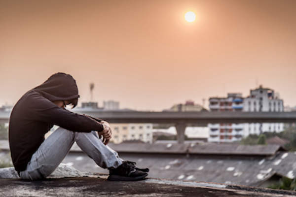 在抑郁症发作的人坐在屋顶上。