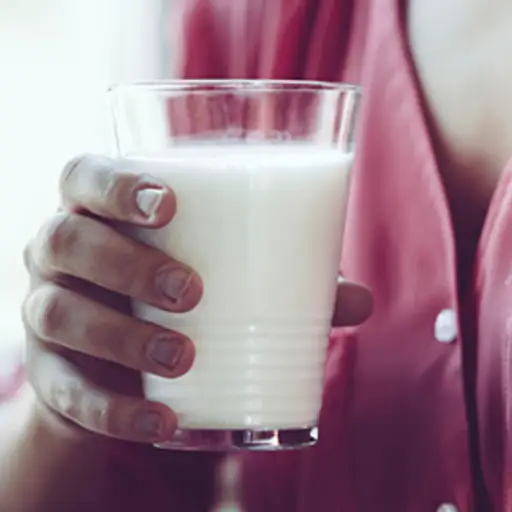 拿着杯牛奶的妇女。