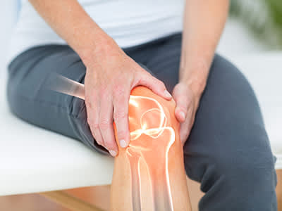 骨痛的人摸着膝盖。