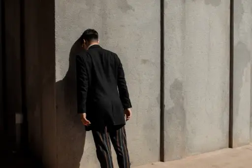 man leaning head against wall