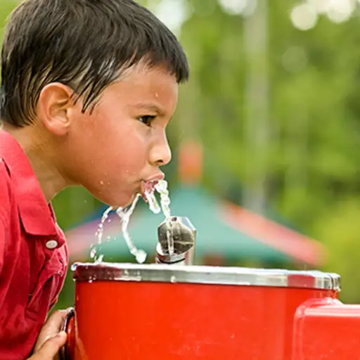 boy drinking from water fountain image