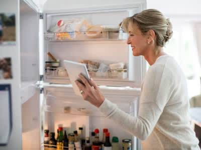 女子检查什么在冰箱里。