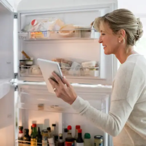 得到食物的妇女在冰箱里面。