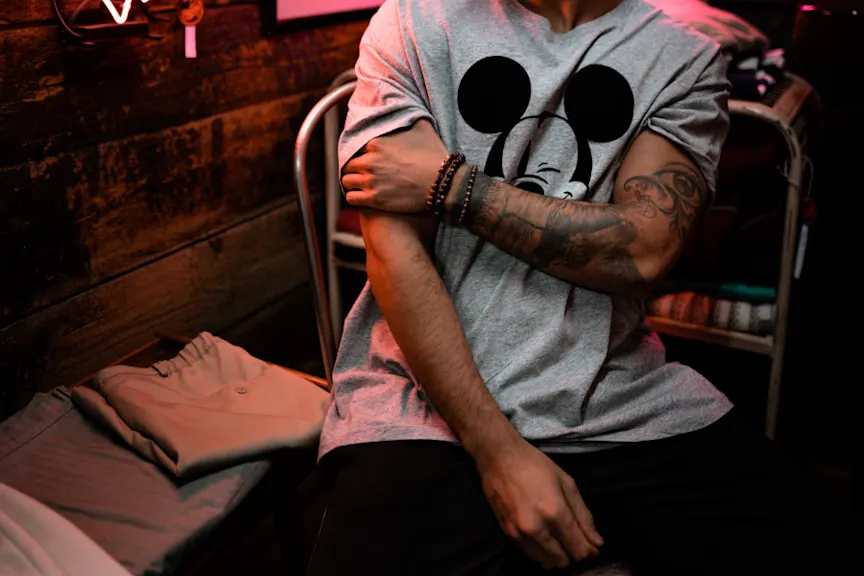 man scratching arm under shirt