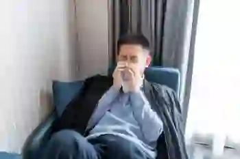 A sick man blows his nose