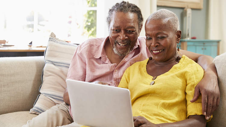 一对老年夫妇在笔记本电脑上研究医疗保险。