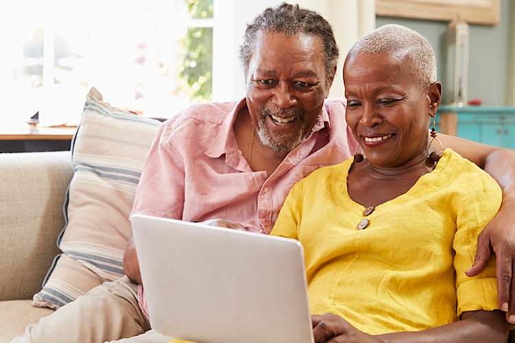 一对老年夫妇在笔记本电脑上研究医疗保险。