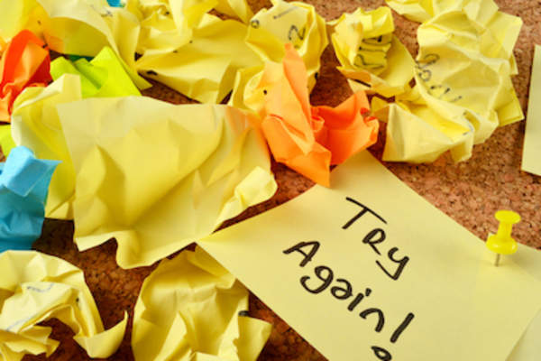 许多便条碾碎,用一个整体便条写着“再试一次!”