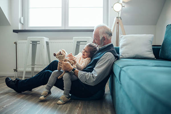 爷爷和孙女在地板上玩。