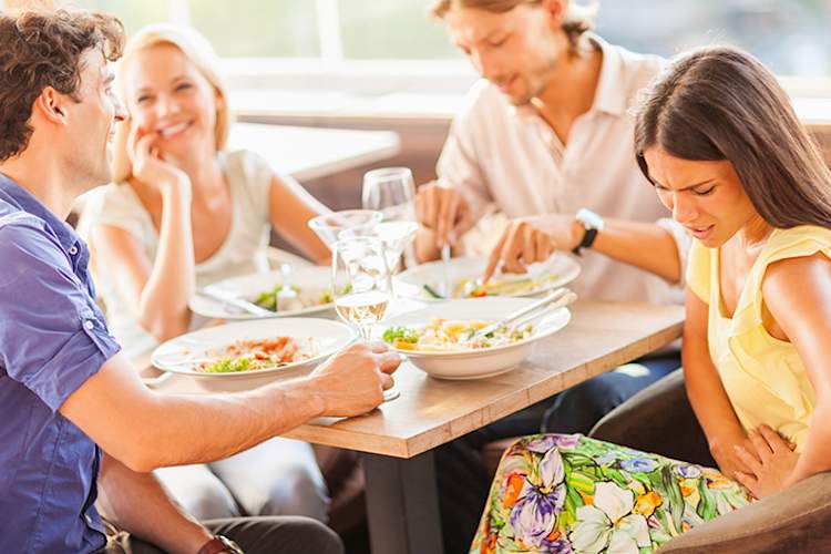 和朋友出去吃午饭时肚子痛的女人。