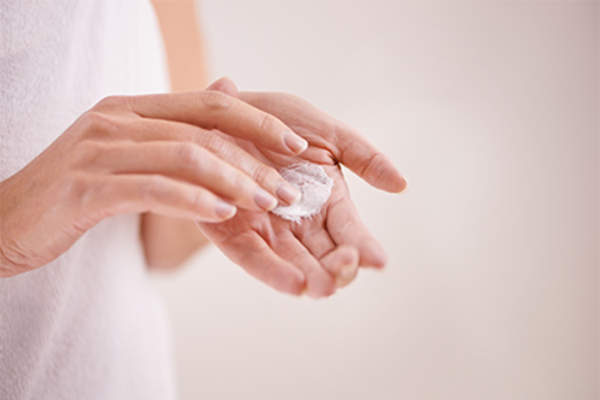 女子在她的手润肤霜。