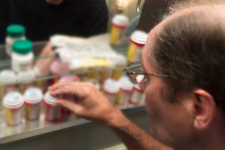 一个人检查他的处方瓶。