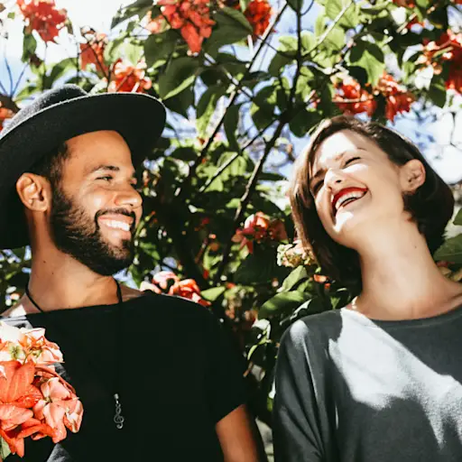 happy laughing couple surrounded by flowering trees