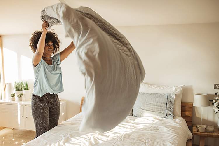 做床的妇女早晨。