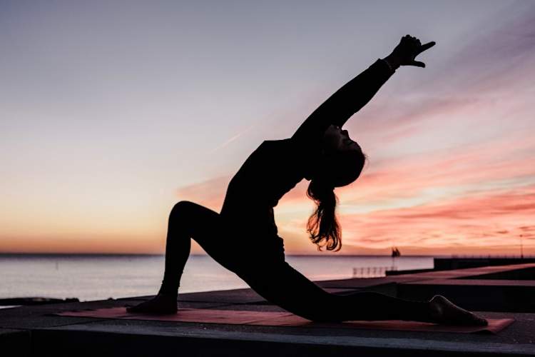 日落时做瑜伽的女人
