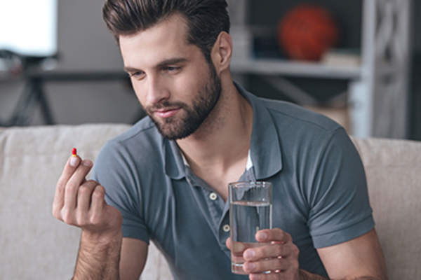 一个男人正要用水吃药。