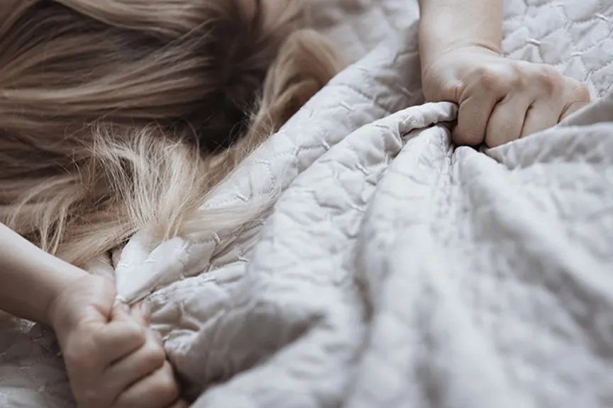 Woman grabbing sheets.