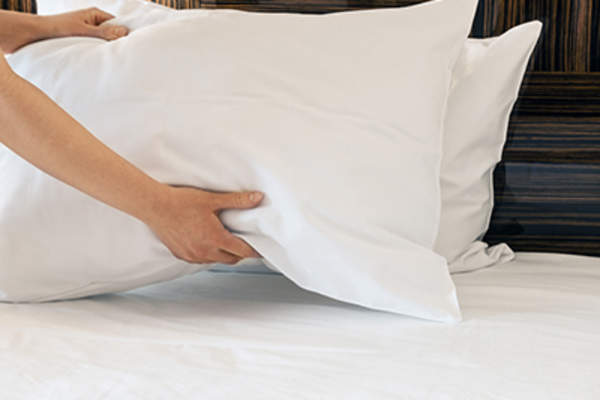 女人在换床单和枕头。