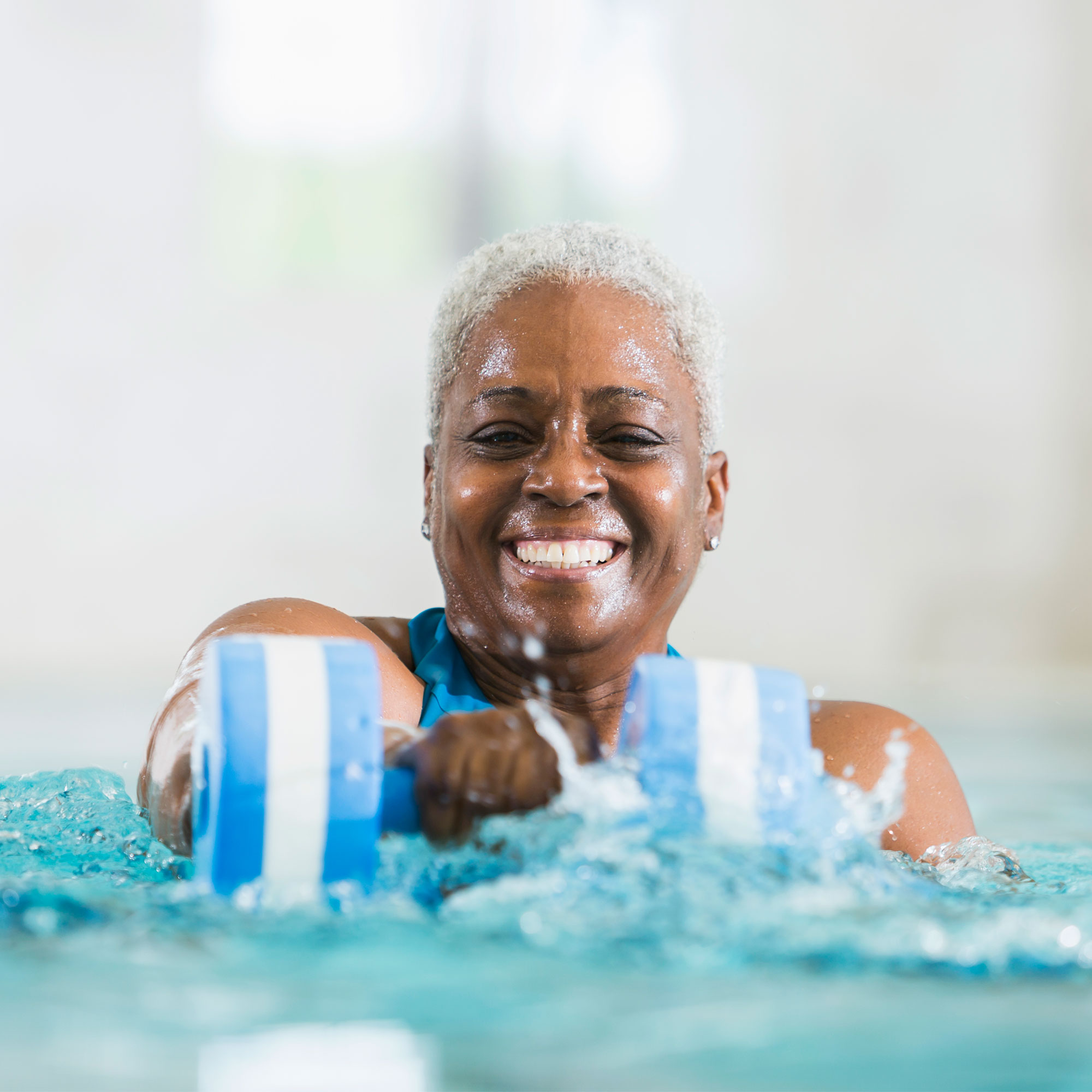 一名女子在游泳池里做水中有氧运动