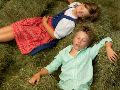 农场的孩子们睡在绿色的干草捆上。