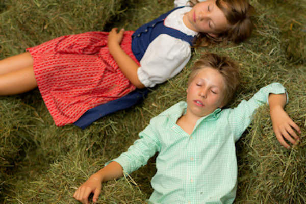 农场的孩子们睡在绿色的干草捆上。