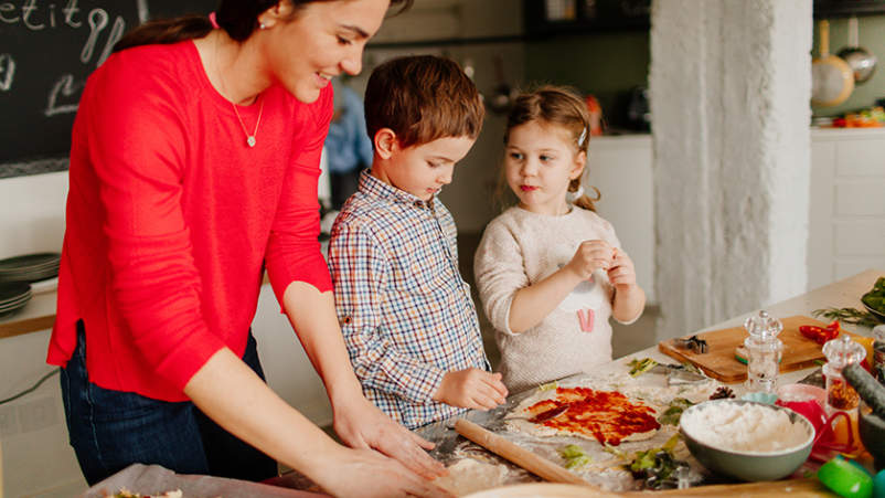 帮助患有类风湿性关节炎的母亲做饭的孩子。