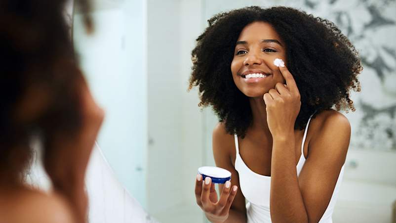 女人涂润肤霜。