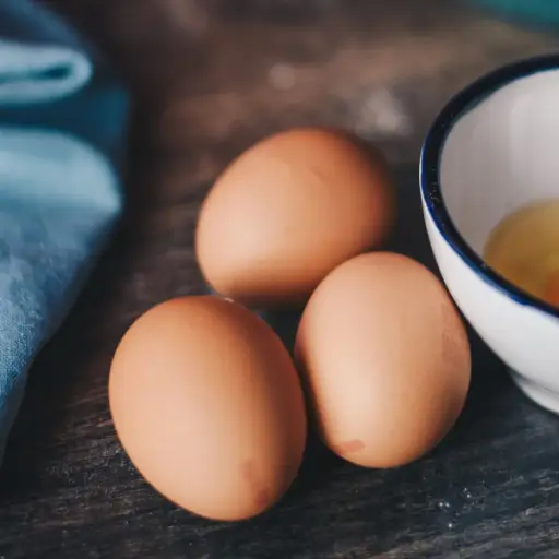 在碗里有三个全棕色的鸡蛋挨着一个破鸡蛋