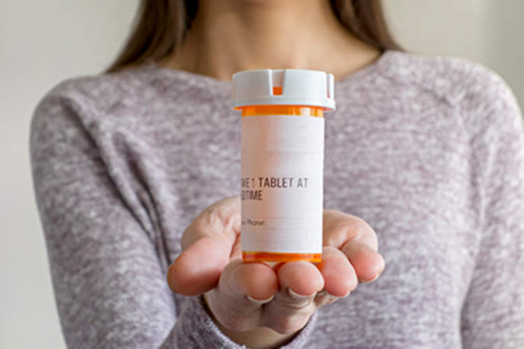 女子持处方药瓶。