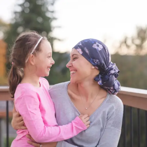 有癌症的年轻母亲微笑对女儿的