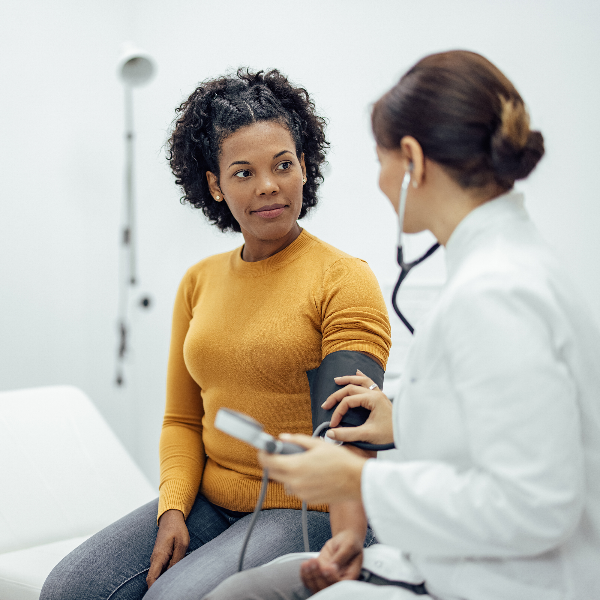 医生测量血压的微笑的女人