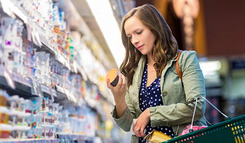 在杂货店看食品标签的女人