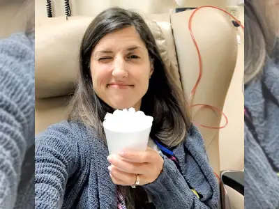 塞布丽娜·斯基尔斯坐在化疗椅上，手里拿着冰片