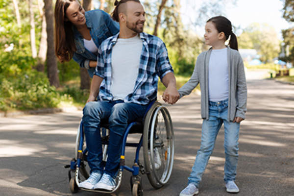 坐轮椅的男人和他的家人在外面。