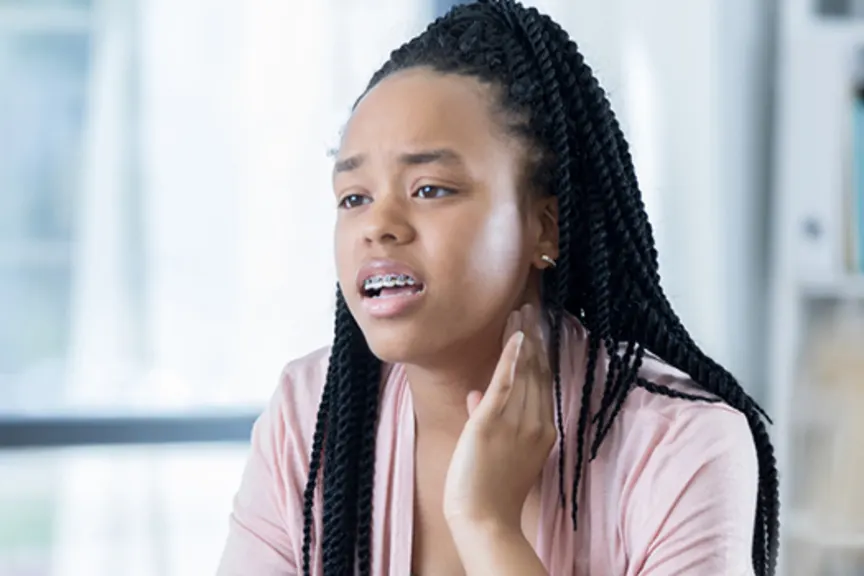 Young woman talking to her doctor about jaw pain.