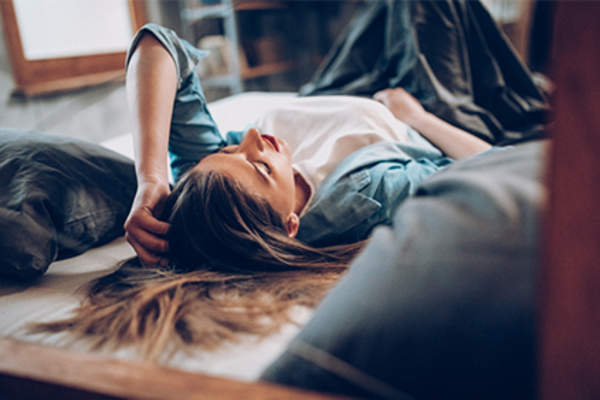 十几岁的女孩躺在她的床上PMS症状。