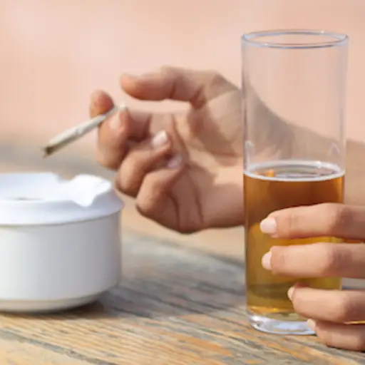 拿着香烟和啤酒的手。