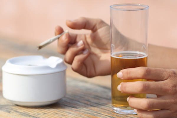 手里拿着烟和啤酒。