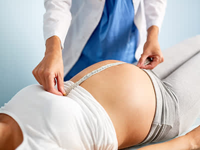 医生正在测量孕妇的胃。