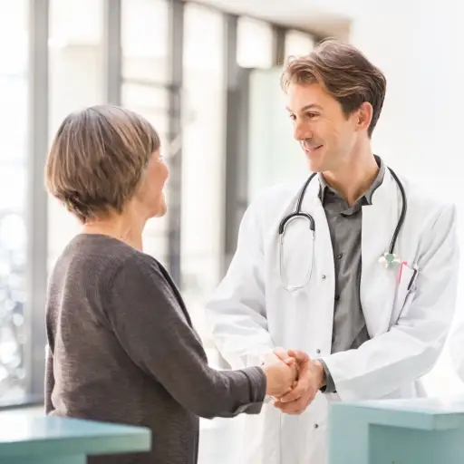 妇女与她的新医生握手。