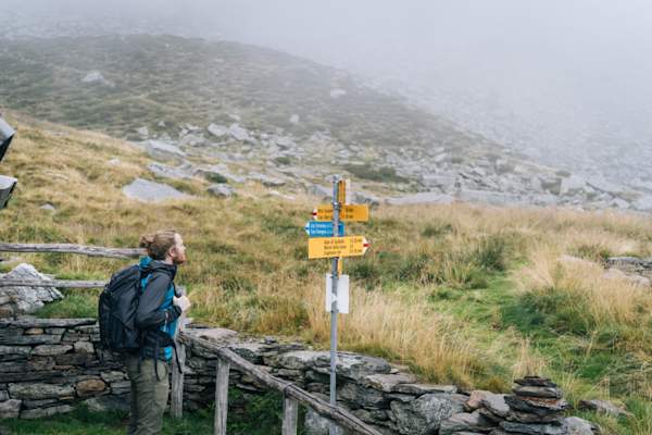 徒步旅行者在外观步道标志为方向