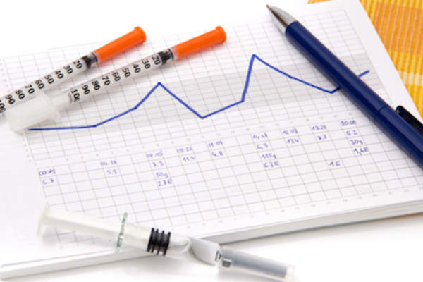 注射器,笔和记事本的跟踪血糖水平。