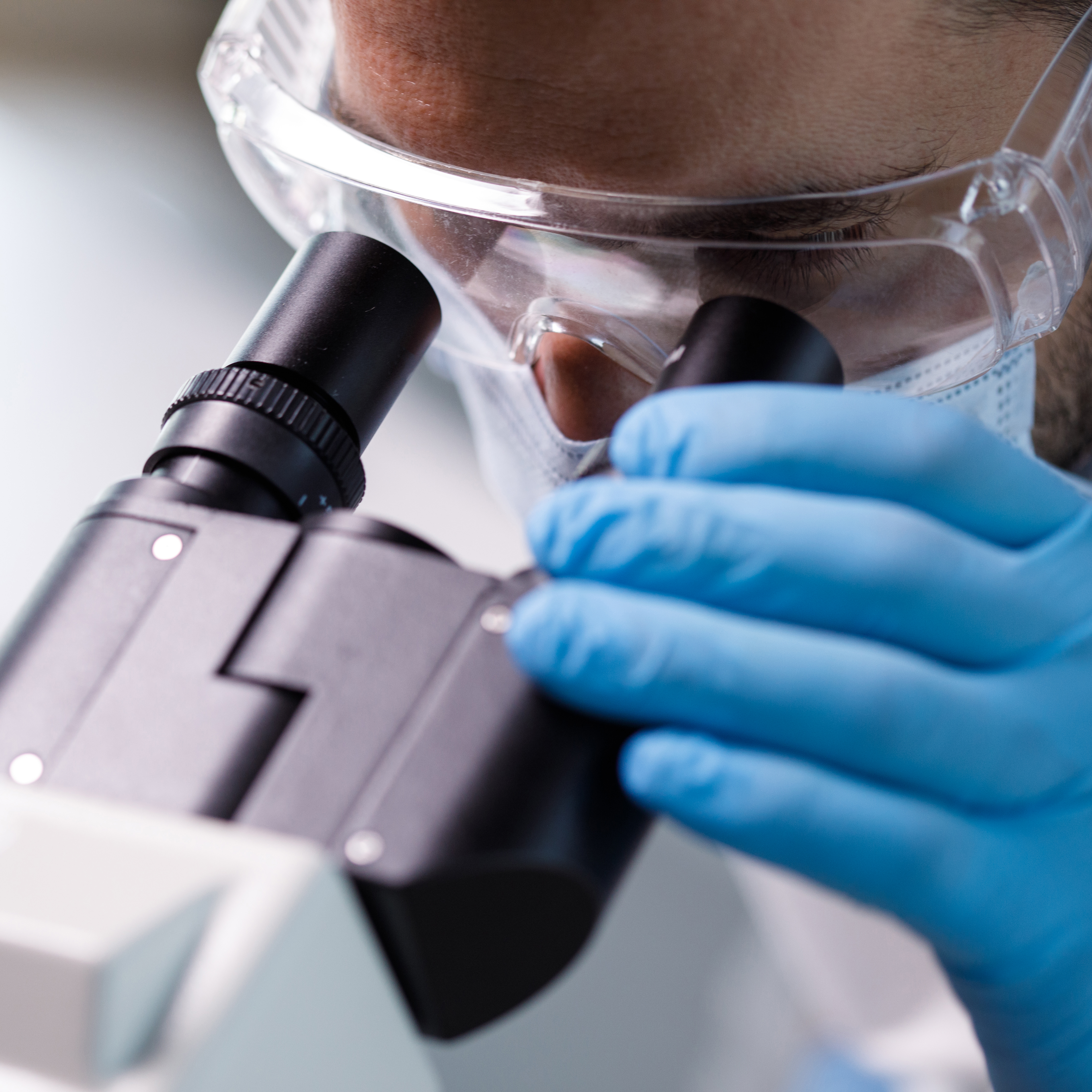 实验室技术人员在显微镜下观察科学样本的特写镜头。