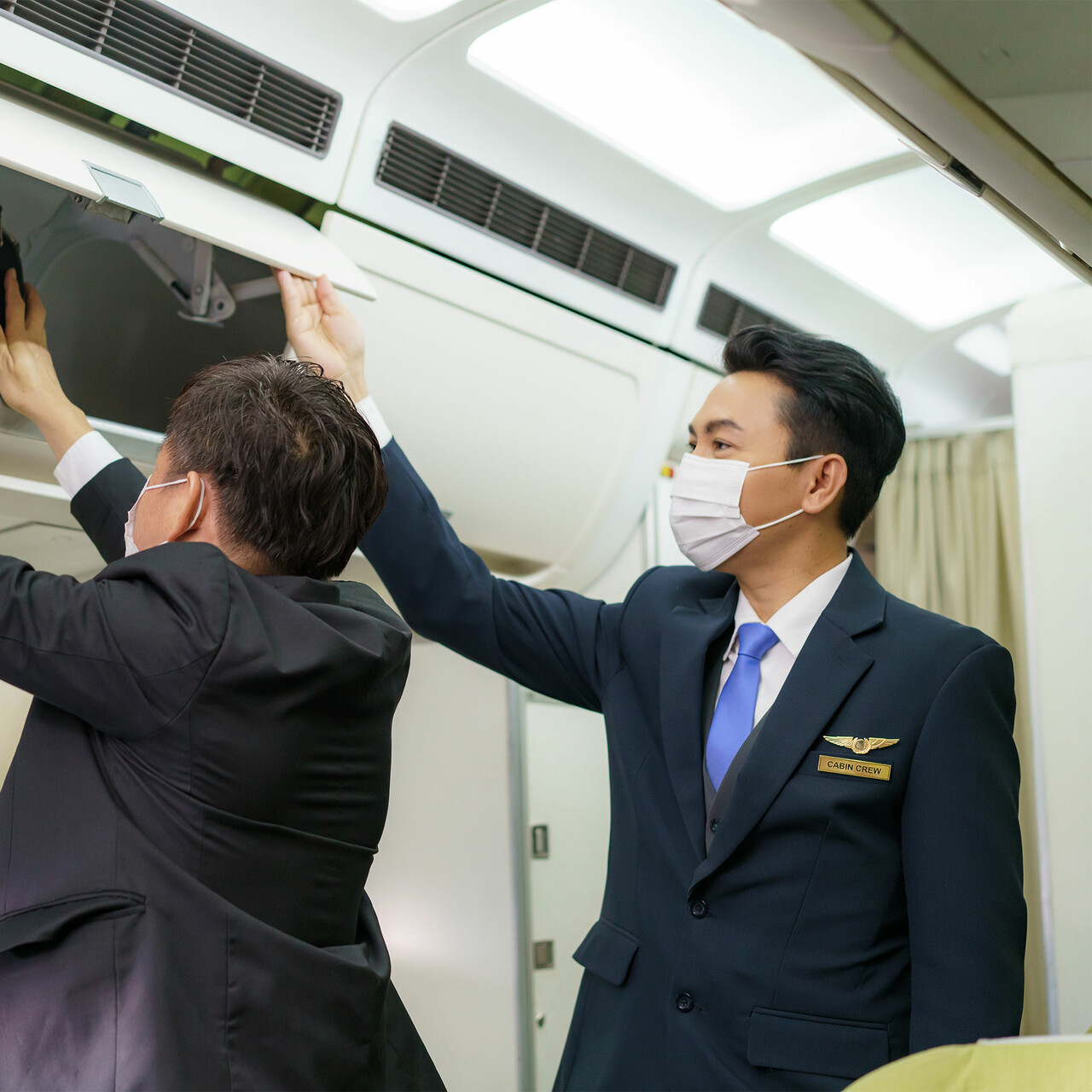 空乘人员帮乘客拿行李