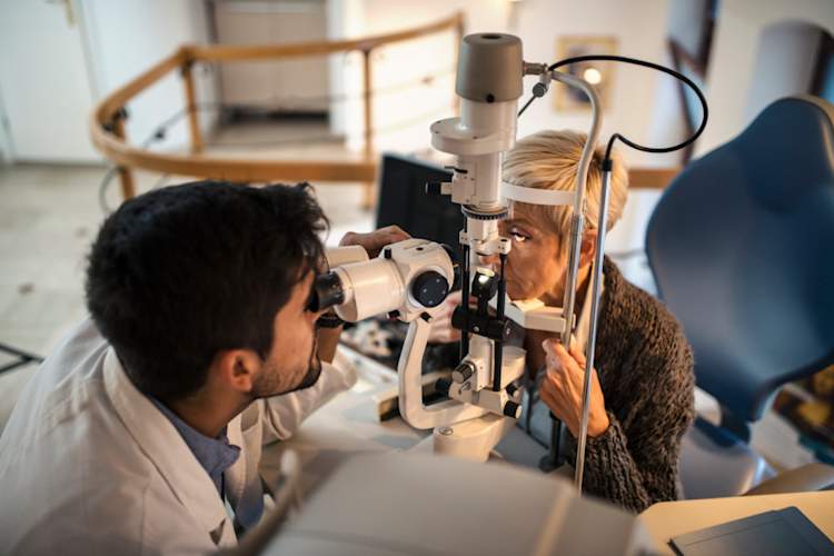 资深女人的年轻眼科医生检查视力