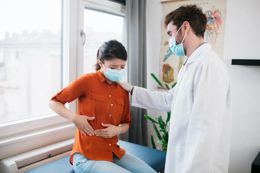 戴着COVID-19口罩与医生交谈