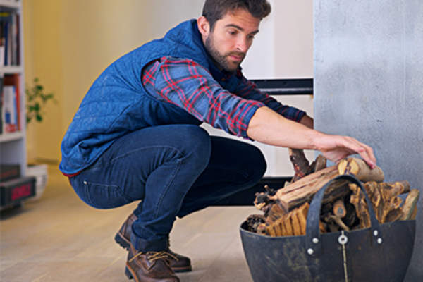 一个人在往篮子里放木柴。