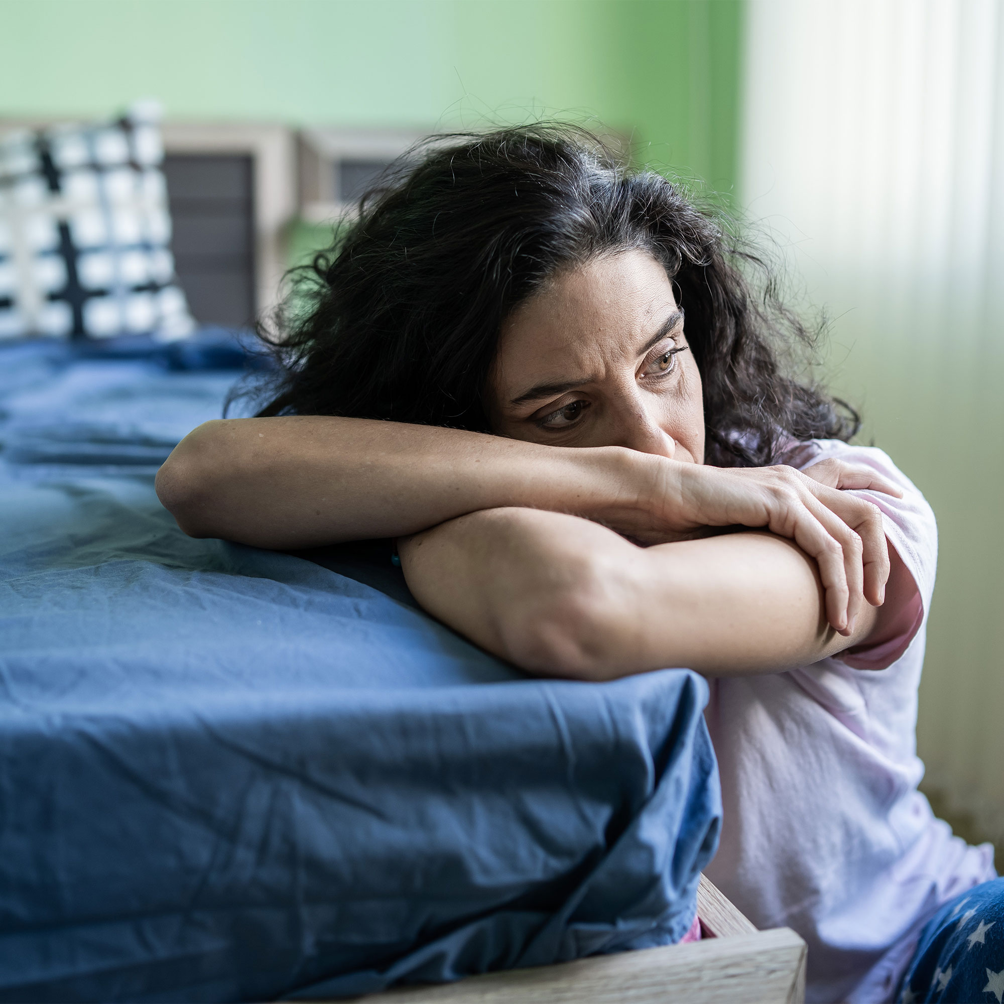 一个担心的女人靠在床上